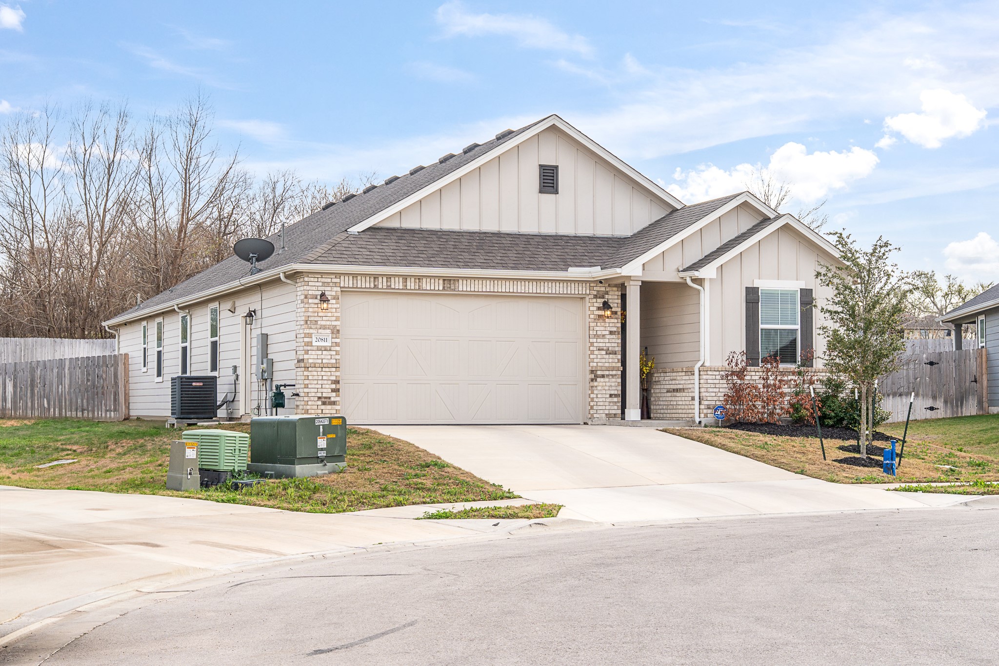 20811 Phebe Foster Street Manor, TX 78653 - Photo 3 of 40 View of front of home with board and batten siding, an attached garage, concrete driveway, and roof with shingles