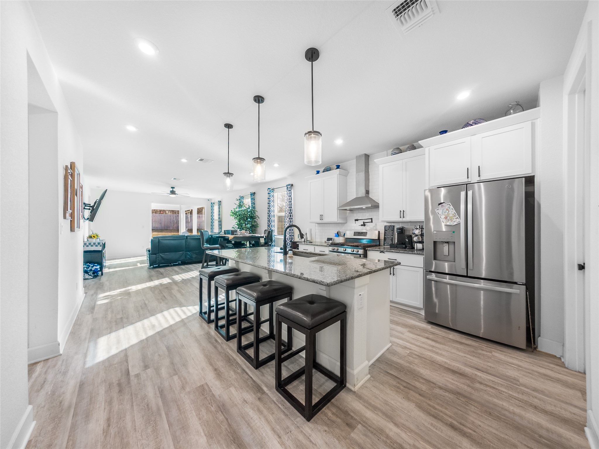 20811 Phebe Foster Street Manor, TX 78653 - Photo 40 of 40 Kitchen featuring white cabinets, stainless steel appliances, open floor plan, dark stone countertops, and an island with sink