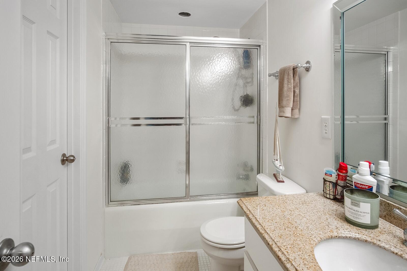 8012 Hollyridge Road, Unit 17U Jacksonville, FL 32256 - Photo 19 of 22 a bathroom with a granite countertop sink toilet and shower