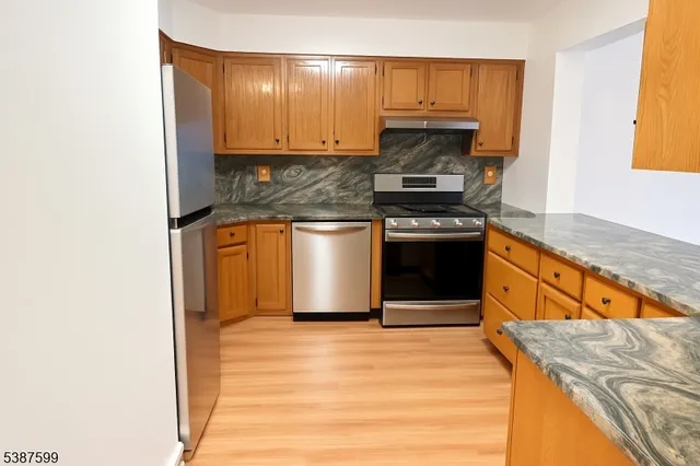 a kitchen with stainless steel appliances granite countertop a stove a sink and a microwave