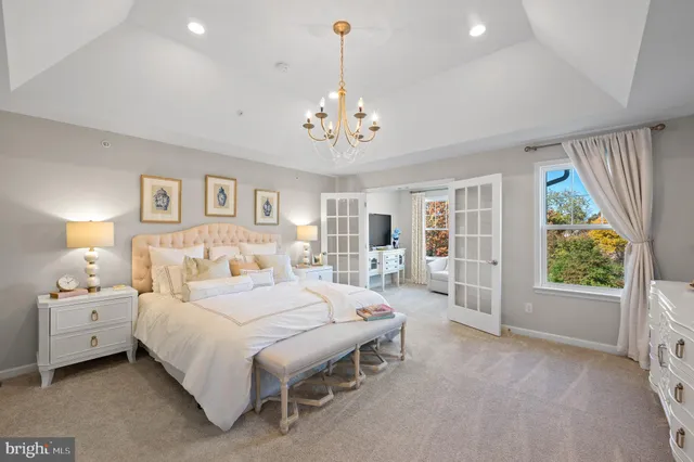 a bedroom with a large bed and a chandelier