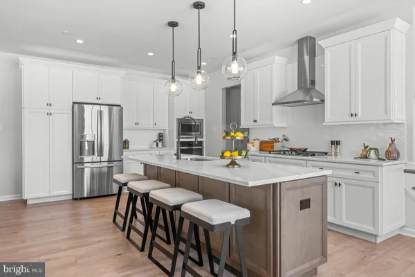 a kitchen with stainless steel appliances a table chairs refrigerator and microwave