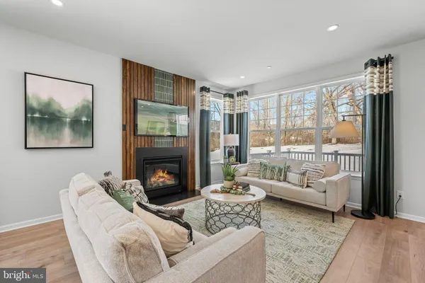 a living room with furniture a large window and a fireplace