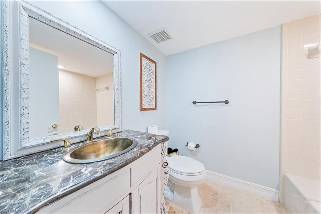 Undisclosed Address Naples, FL 34105 - Photo 16 of 24 a bathroom with a sink a toilet and a mirror