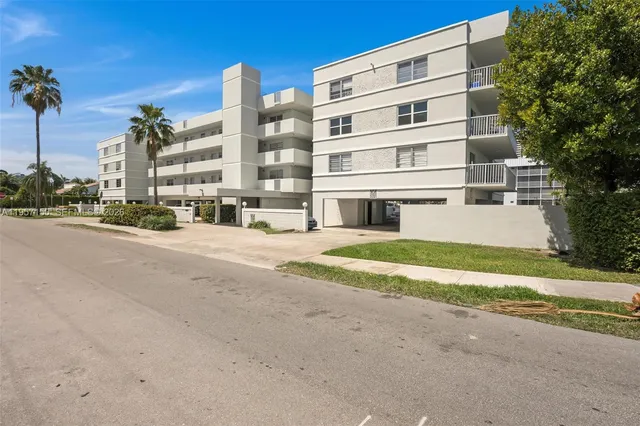 a view of a tall building next to a yard