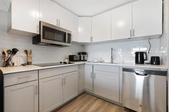a kitchen with white cabinets and white appliances