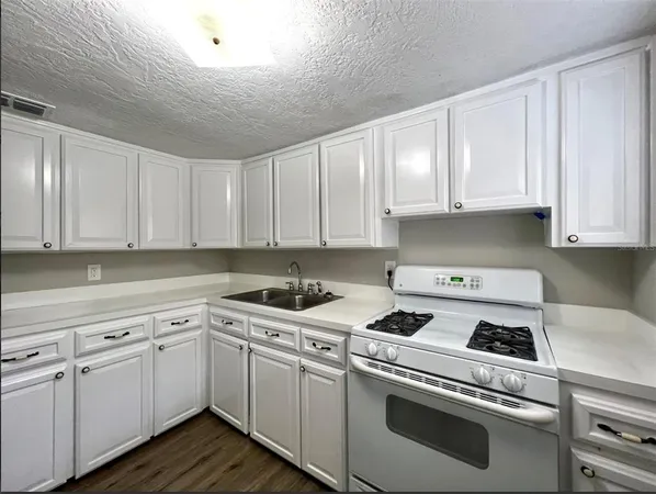 a kitchen with cabinets appliances a sink and a counter top space