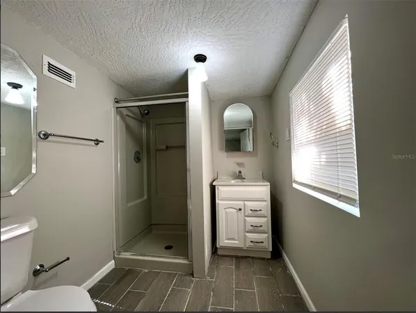 a bathroom with a shower a sink and a toilet