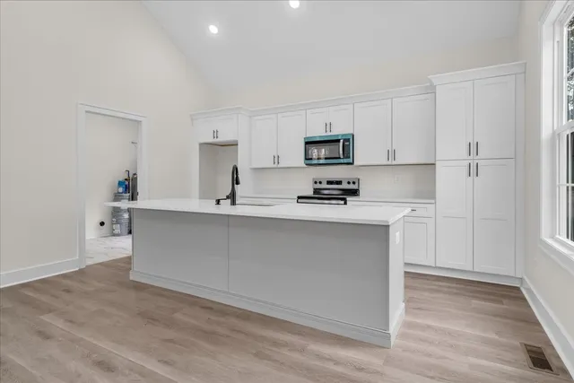 a kitchen with stainless steel appliances a stove a sink and a refrigerator
