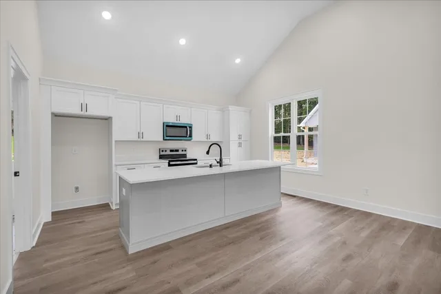 a kitchen with granite countertop a sink stove and refrigerator