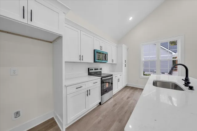 a kitchen with stainless steel appliances a sink stove and cabinets