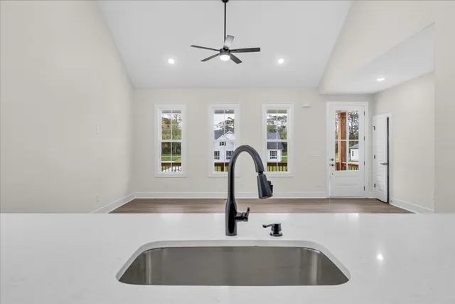 a kitchen with a sink a faucet cabinets and window
