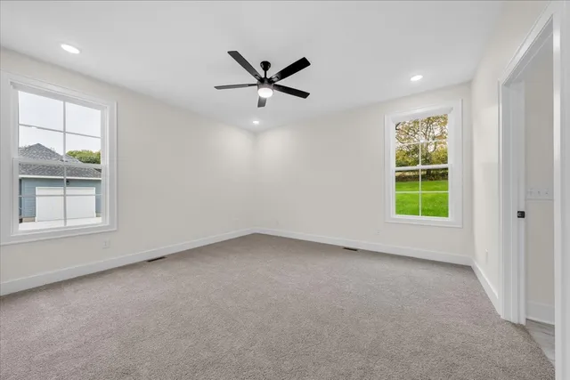 an empty room with closet and windows