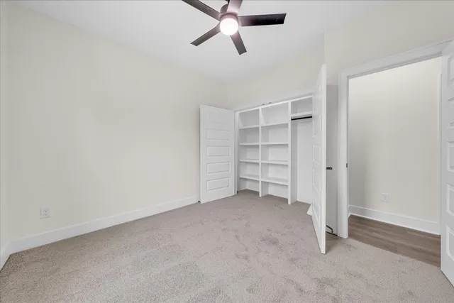 an empty room with a window and a fan