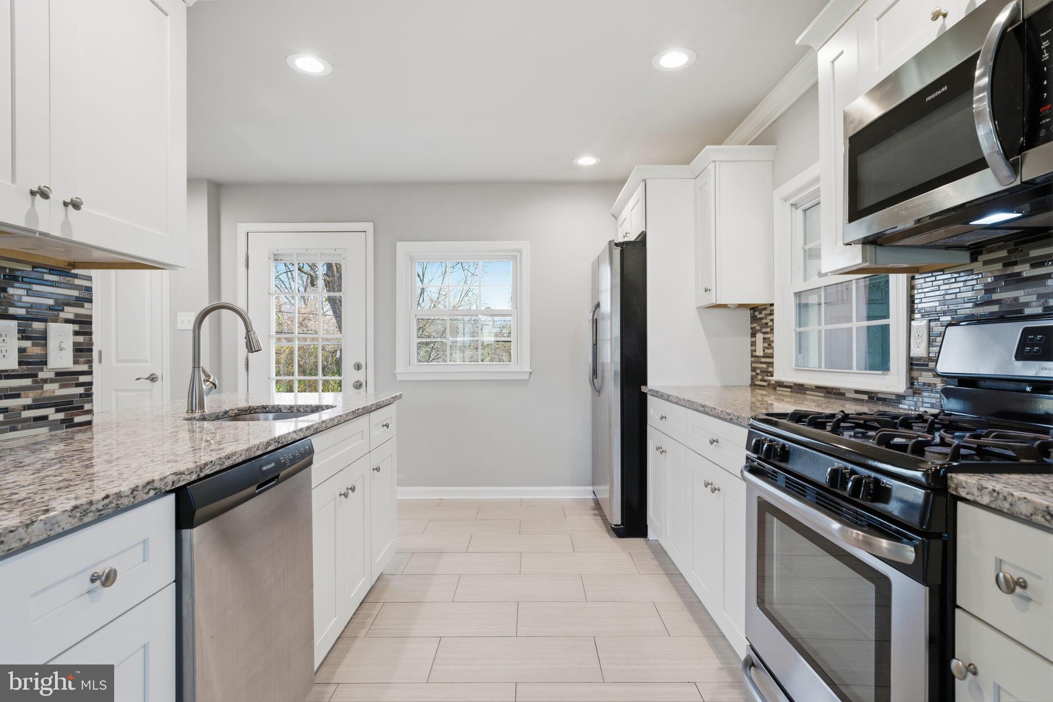 208 Trenton Road Fairless Hills, PA 19030 - Photo 11 of 35 a kitchen with stainless steel appliances granite countertop a stove a sink and a microwave