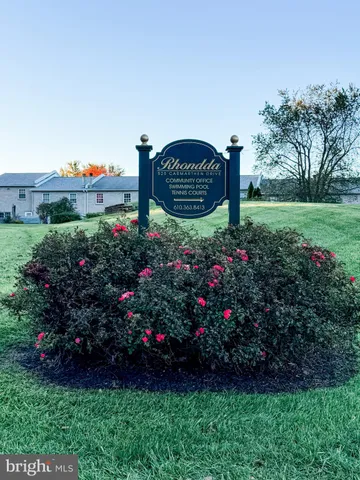 a view of a sign sitting in the middle of a garden
