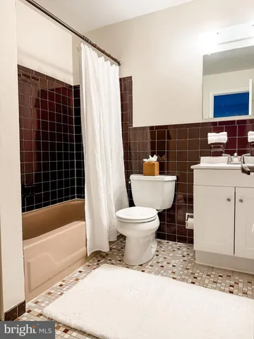 a white toilet sitting next to a bathroom sink and a tub