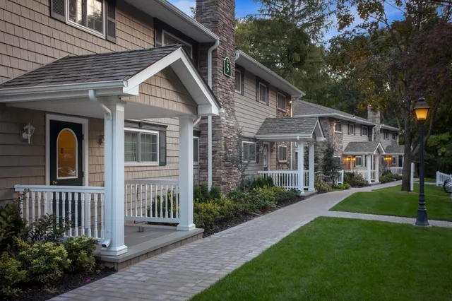 a front view of a house with a garden and trees