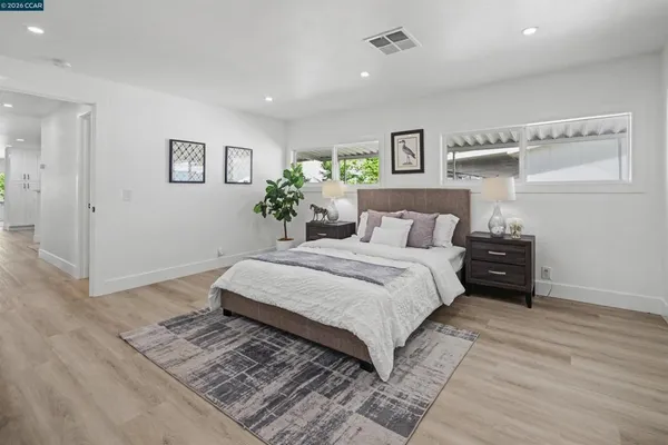 a bedroom with a large bed and a wooden floor
