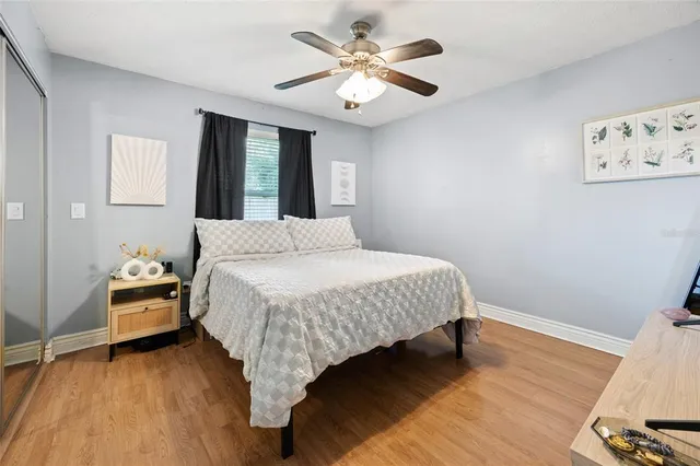 a view of a swimming pool with a yard and large trees