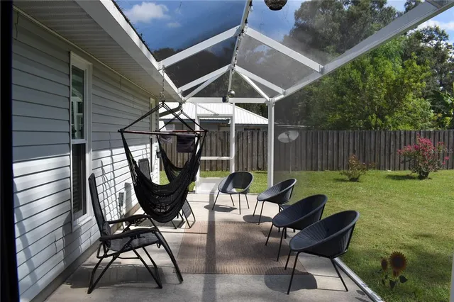 a backyard of a house with table and chairs
