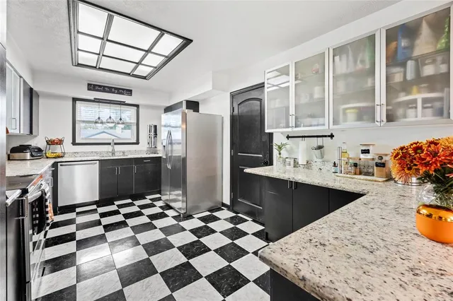 a kitchen with stainless steel appliances granite countertop a sink stove and refrigerator