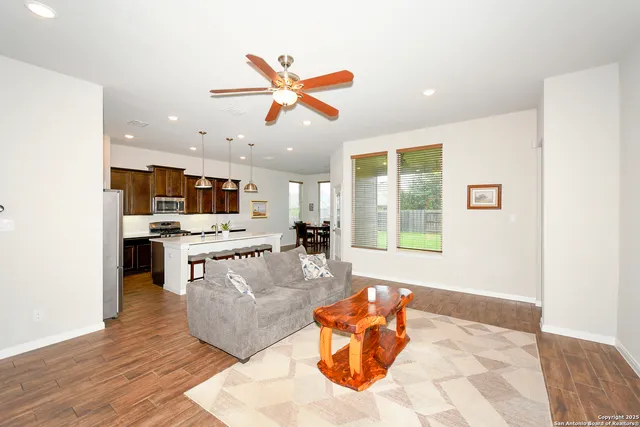 a living room with stainless steel appliances furniture and a large window