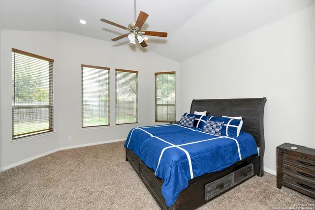 a bedroom with a bed a chandelier and a window