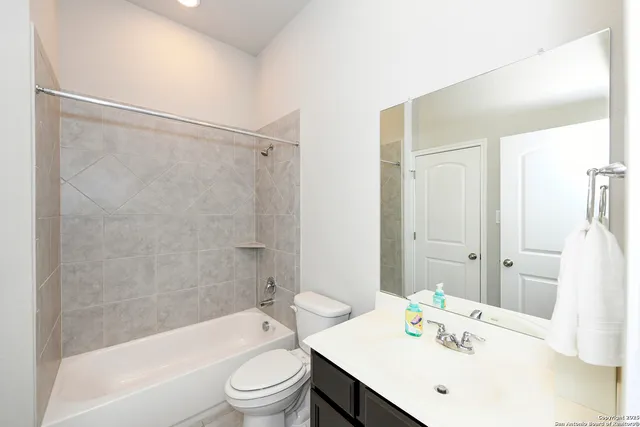 a bathroom with a sink mirror toilet and bathtub