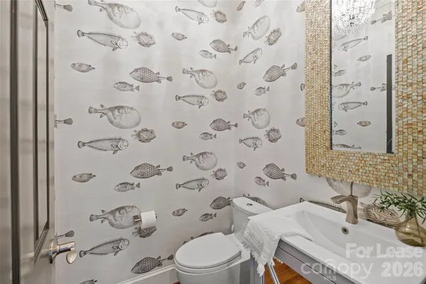 a bathroom with a sink and mirror with toilet