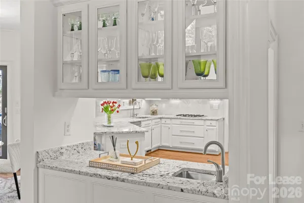 a kitchen with stainless steel appliances granite countertop a sink and a white cabinets