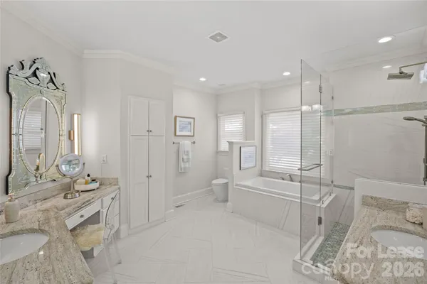 a spacious bathroom with a double vanity sink a mirror and a shower