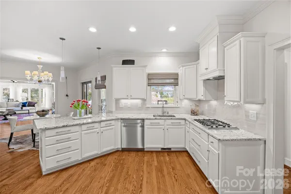a large white kitchen with cabinets a sink and appliances