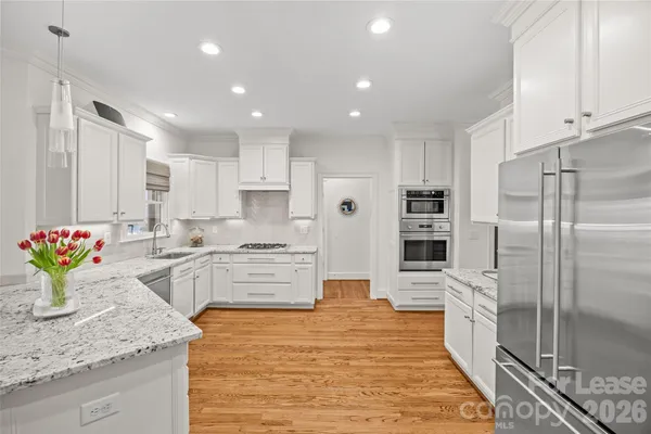 a kitchen with stainless steel appliances kitchen island granite countertop a refrigerator and a sink