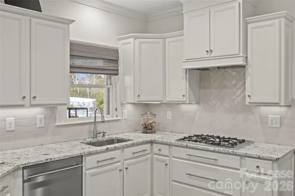 a kitchen with granite countertop white cabinets and white appliances