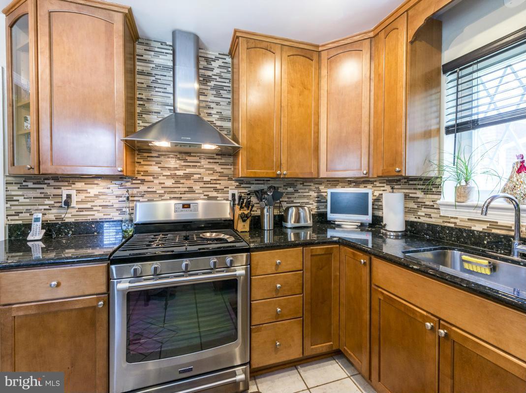 1312 Leegate Road Northwest Washington, DC 20012 - Photo 11 of 30 a kitchen with stainless steel appliances granite countertop a stove a sink and a microwave