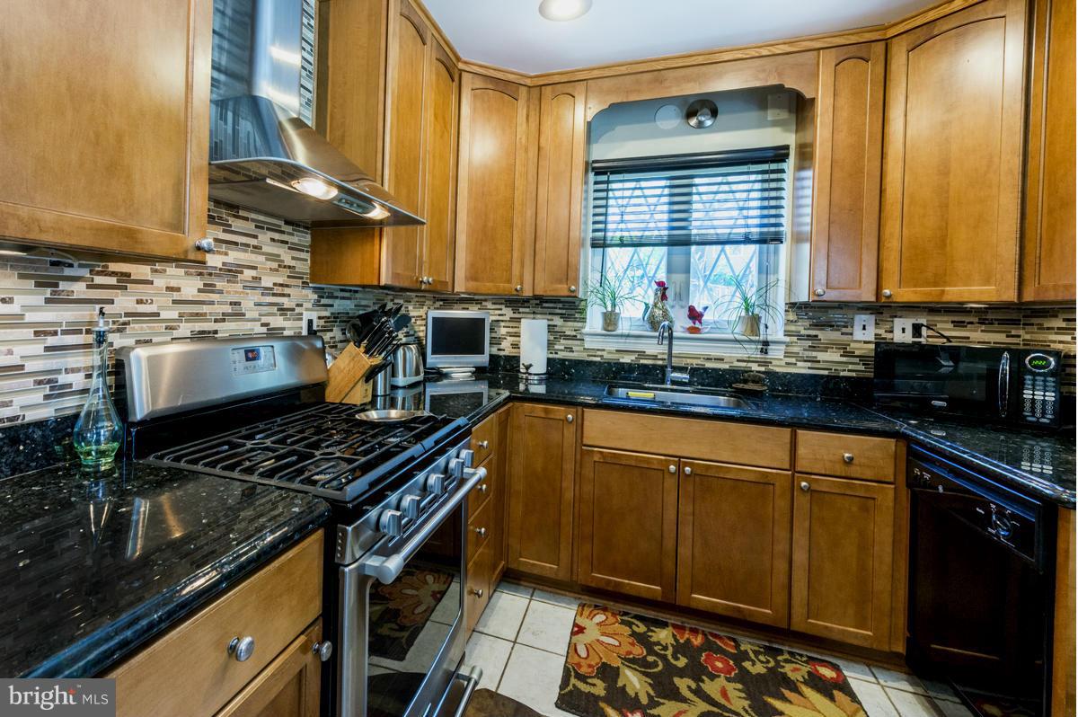 1312 Leegate Road Northwest Washington, DC 20012 - Photo 12 of 30 a kitchen with stainless steel appliances a stove a sink and a microwave