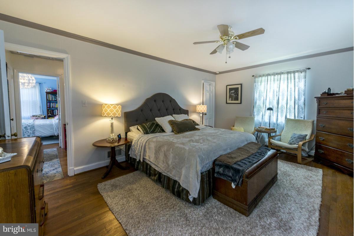 1312 Leegate Road Northwest Washington, DC 20012 - Photo 16 of 30 a spacious bedroom with a bed and a chandelier