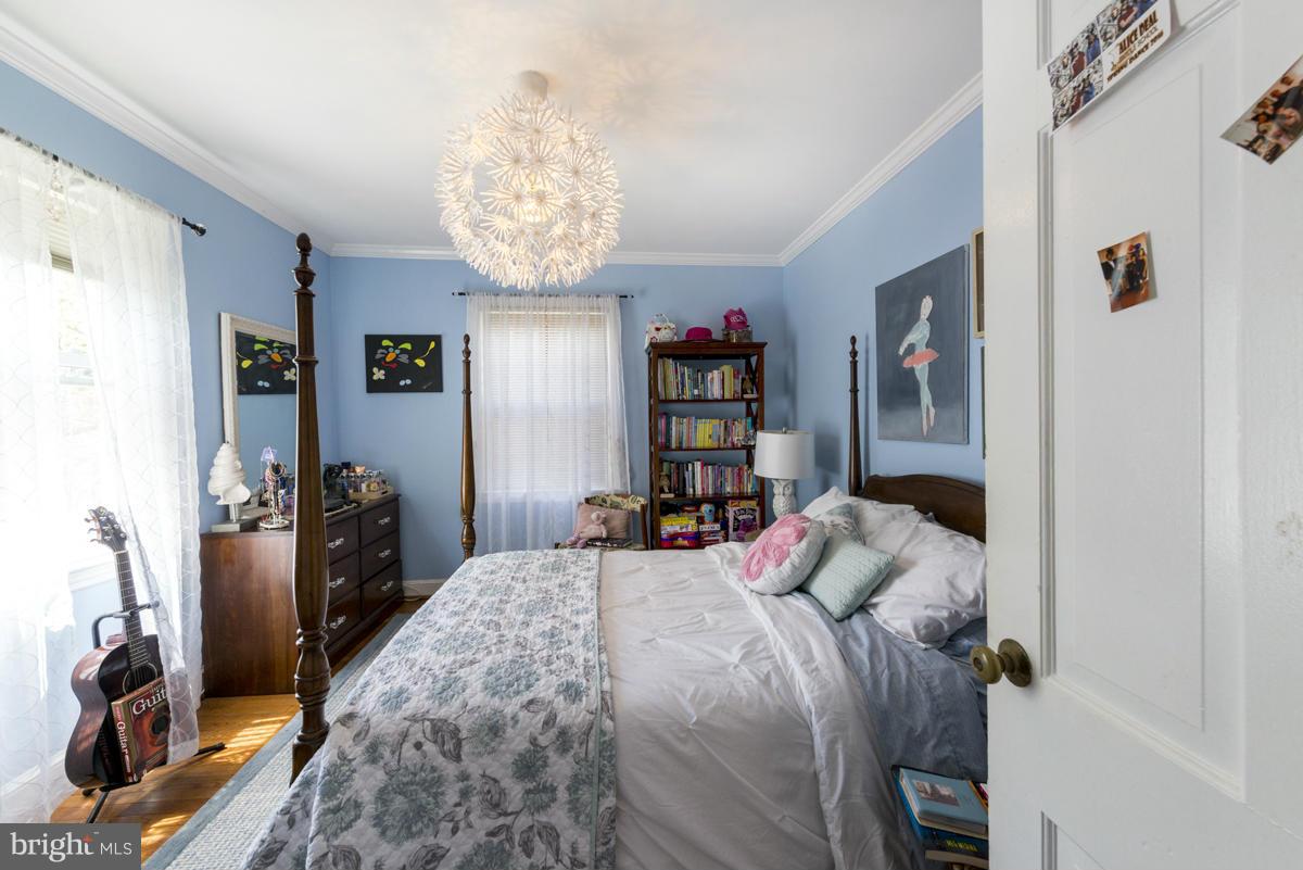 1312 Leegate Road Northwest Washington, DC 20012 - Photo 19 of 30 a bedroom with a bed and a chandelier
