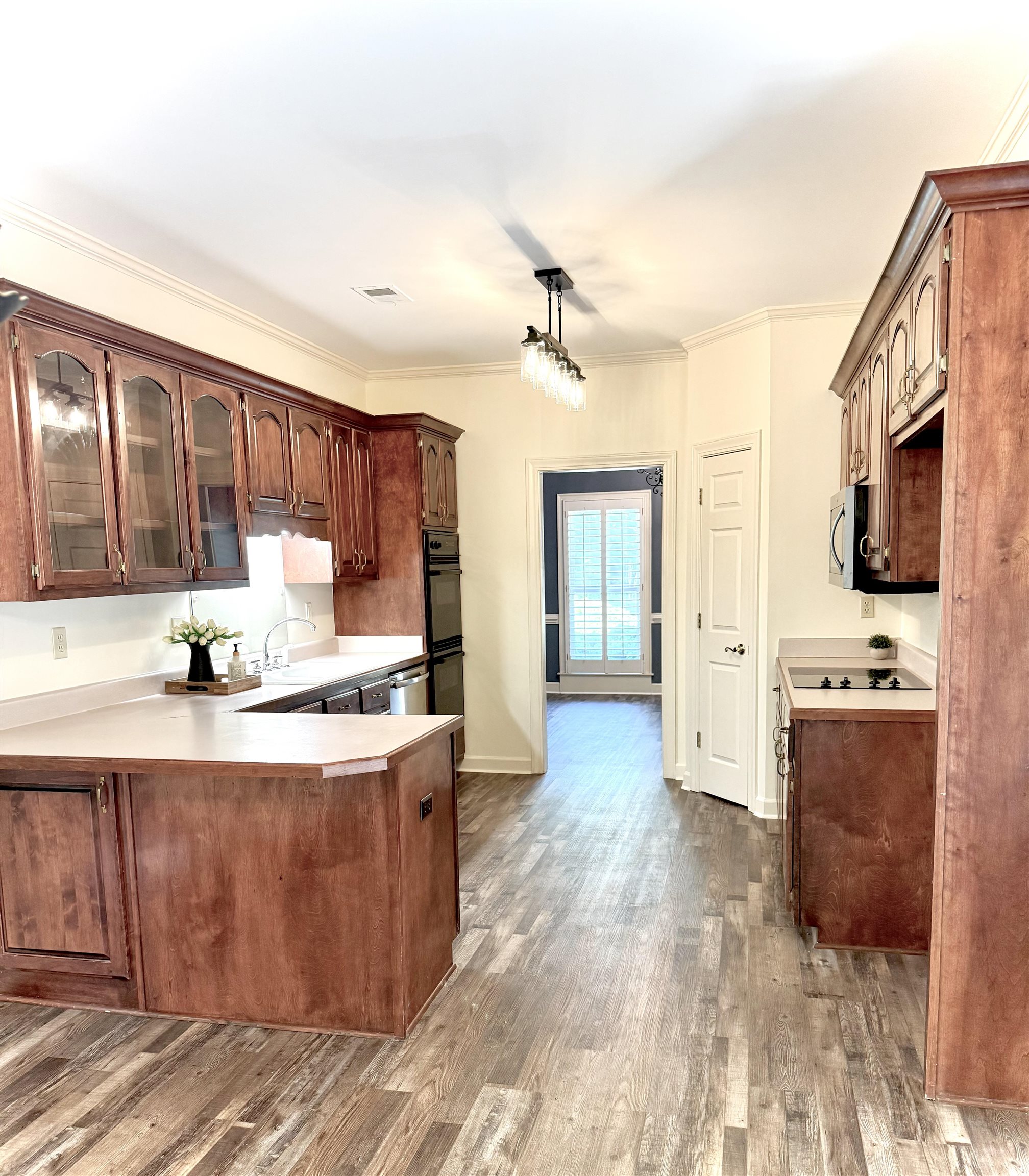 756 Crestover Drive Collierville, TN 38017 - Photo 11 of 38 a kitchen with stainless steel appliances granite countertop a stove top oven a sink dishwasher a refrigerator and a dining table with wooden floor