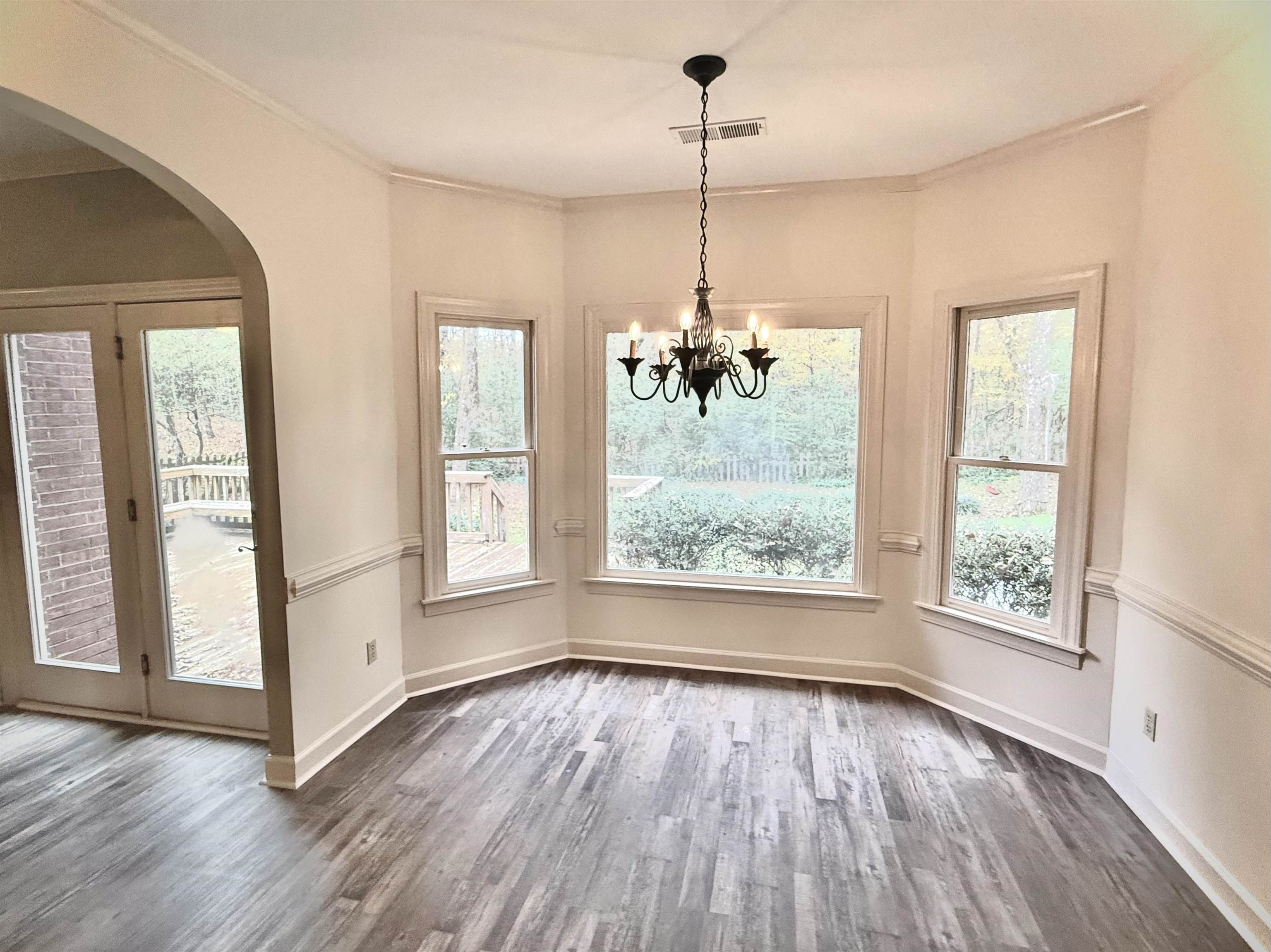 756 Crestover Drive Collierville, TN 38017 - Photo 14 of 38 a view of an empty room with window wooden floor and a kitchen view