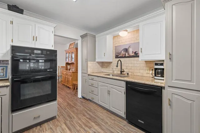 a kitchen with granite countertop white cabinets and stainless steel appliances