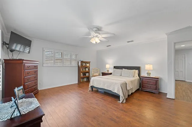 a spacious bedroom with a bed and a flat screen tv