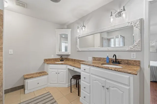 a spacious bathroom with a granite countertop sink a mirror and a