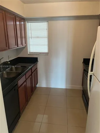 a kitchen with a sink a refrigerator and window