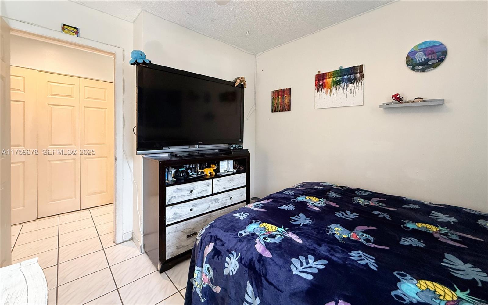 20520 Southwest 124th Place Miami, FL 33177 - Photo 14 of 34 a bedroom with a bed and a flat screen tv
