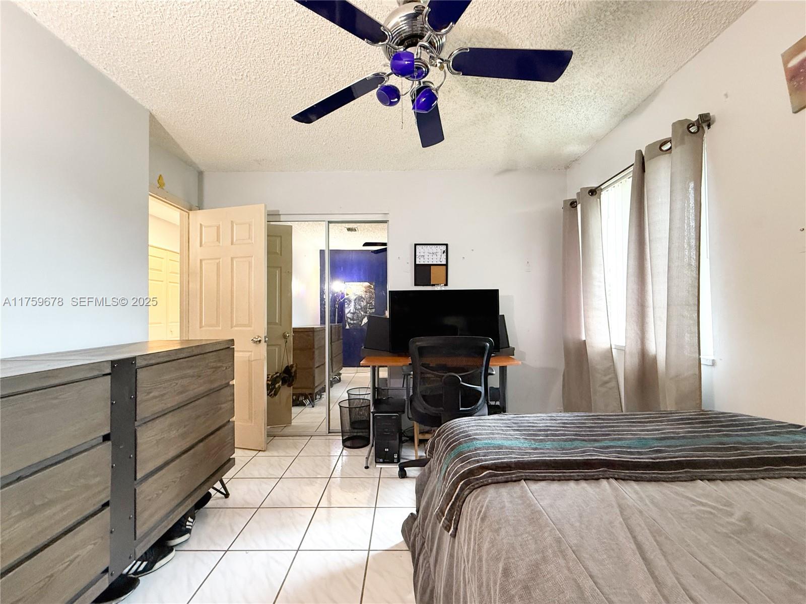 20520 Southwest 124th Place Miami, FL 33177 - Photo 15 of 34 a bedroom with a bed and a flat screen tv