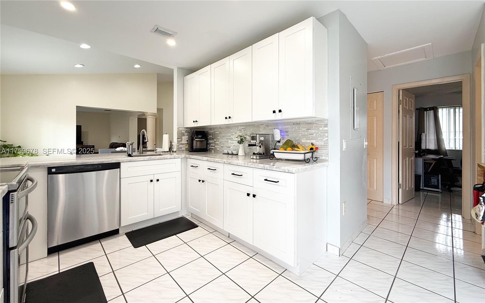 20520 Southwest 124th Place Miami, FL 33177 - Photo 21 of 34 a kitchen with white cabinets a sink stove and refrigerator