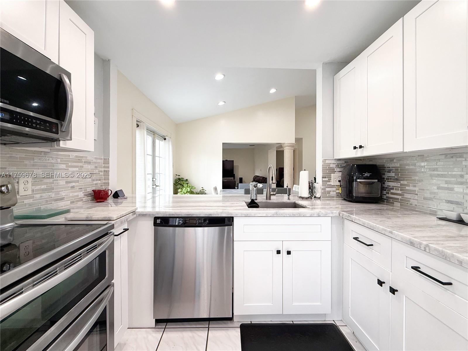 20520 Southwest 124th Place Miami, FL 33177 - Photo 23 of 34 a kitchen with stainless steel appliances white cabinets and a sink