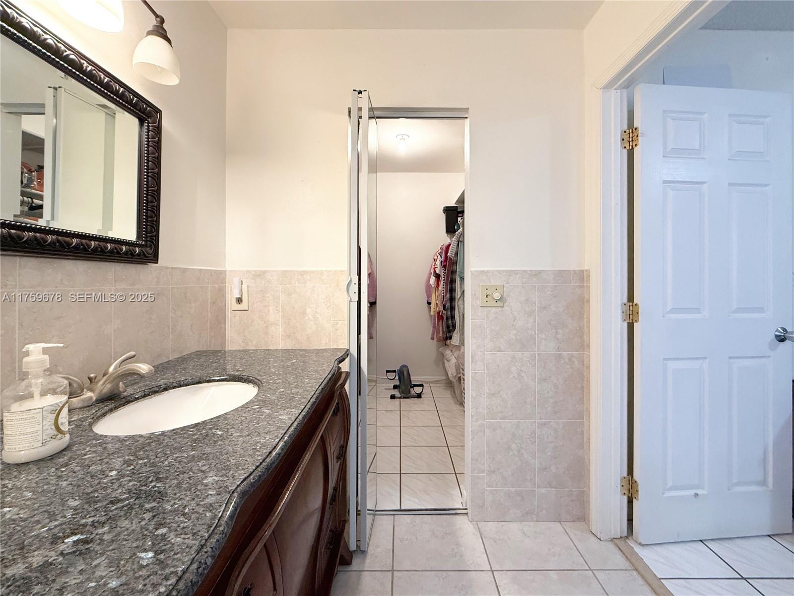 20520 Southwest 124th Place Miami, FL 33177 - Photo 8 of 34 a bathroom with a granite countertop sink and a mirror